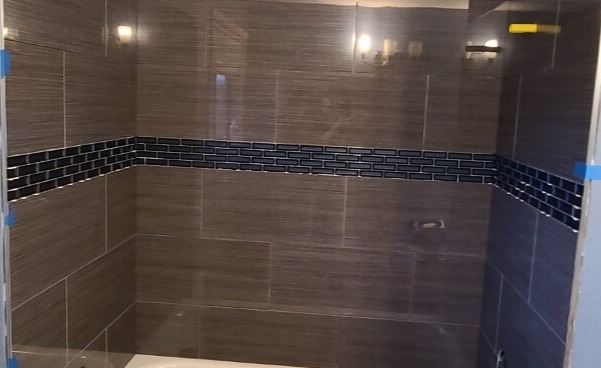 Porcelain tub surround with glass accent band